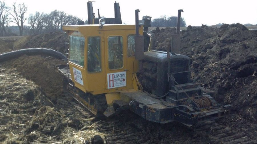 Heinsohn tile plow working through a field in early spring