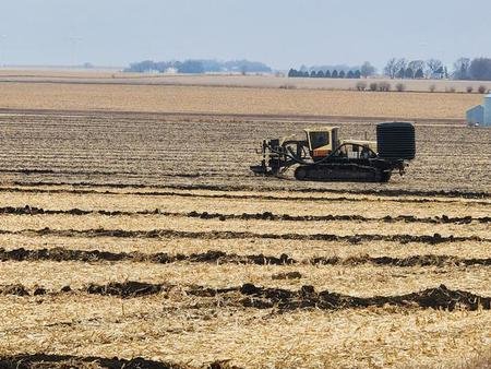 Tiling machine working a harvested field in northwest Iowa